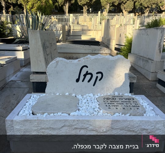 מצבת אבן טבעית מעוצבת עם חלוקי נחל לבנים וכיתוב מיוחד